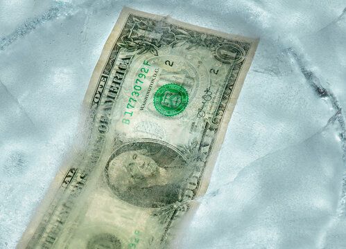 1 dollar bill frozen under a layer of ice, the concept of the global financial crisis or the decline of the dollar in the World Market