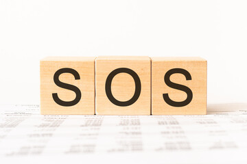 Word sos. Wooden small cubes with letters isolated on white background with copy space available.Business Concept image.