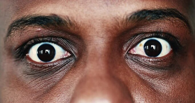 Extreme face close-up, macro eyes of black African man looking sideways