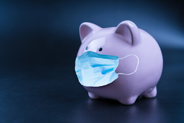Pig piggy bank with medical mask. Close up. Money saving concept in time of coronavirus pandemic COVID-19. Making money in an epidemic