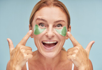 Happy mature lady moisturizing skin around her skin while using patches
