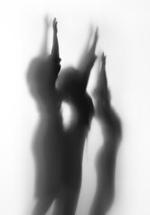 Diffuse body shape silhouette of three people in black and white.