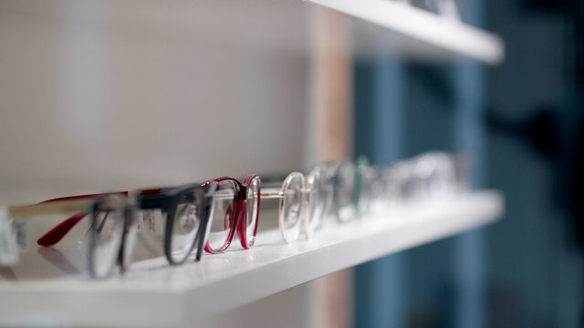 Different colored eyeglasses on a shelf