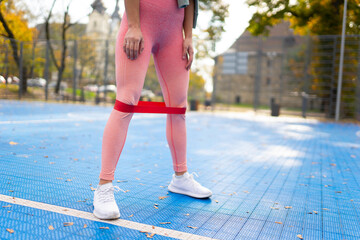 Sportswoman doing exercises with fitness rubber band