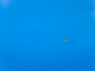 Fototapeta na wymiar Small yellow helicopter at blue sky