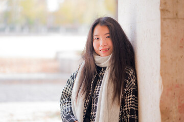 Fototapeta premium lifestyle portrait of young and beautiful Asian Japanese tourist woman smiling happy enjoying city tour walking around historic district on a sunny winter day in holidays travel