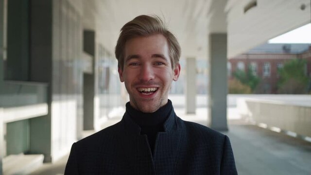 Portrait Happy european man dancing with folder of documents in hand in urban background, showing yeah gesture victory, he achieved result, goals. Amazed Handsome guy shocked, saying Wow. Slow motion