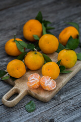 Tangerines with leaves on an old wooden background