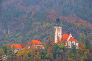 Famous Bled Lake in Triglav National Park in the Julian Alps with a forest in autumn colors