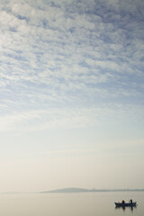 Fishermen on the fishing boat in Ulubat lake and beautiful blue cloudy sky