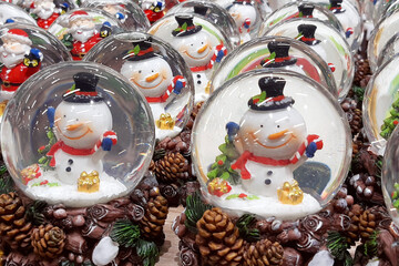 Lots of snow balls with happy snowmen. Christmas and new year. Holiday souvenir. Glass ball.