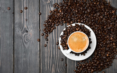 Layout, white cup with espresso coffee and grains on a wooden dark table, copy space for text, top view
