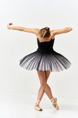 Ballerina in pointe shoes and tutu dancing on isolated background 