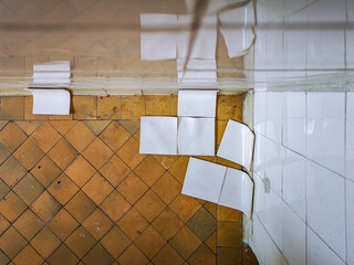 White tiles sliding by the wall in old abandoned hospital