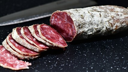 Slices of Italian artisanal Felino salami on a kitchen cutting board. Felino, Parma, Emilia Romagna / Italy