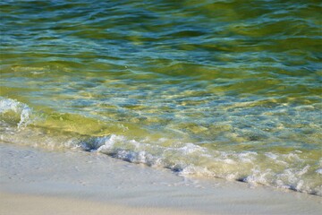 Wave on the shore, white foam, wet sand, ocean green, macro photography