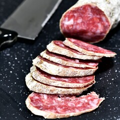 Slices of Italian artisanal Felino salami on a kitchen cutting board. Felino, Parma, Emilia Romagna / Italy