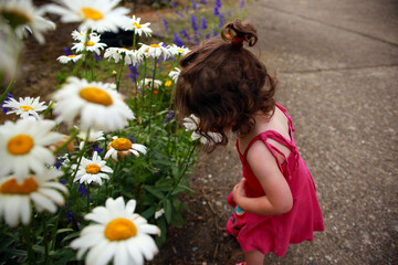 Naklejka premium Niña oliendo flores 