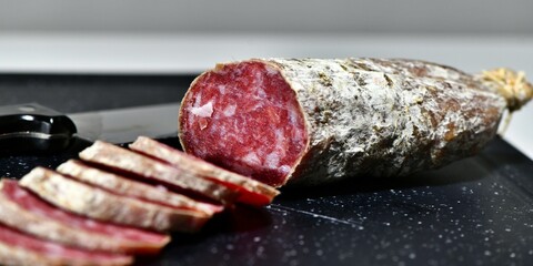 Slices of Italian artisanal Felino salami on a kitchen cutting board. Felino, Parma, Emilia Romagna / Italy