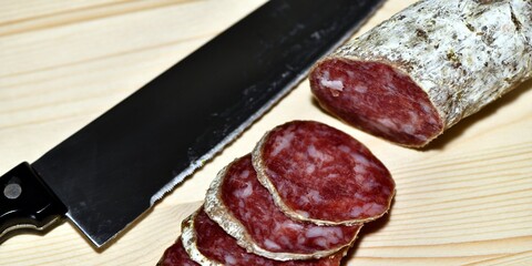 Slices of Italian artisanal Felino salami on a kitchen cutting board. Felino, Parma, Emilia Romagna / Italy