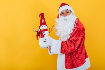 Santa Claus holding a snowman on yellow background. Christmas concept