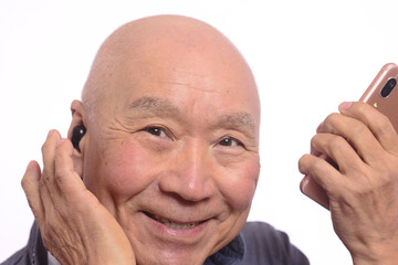 ワイヤレスイヤホンで音楽を聴く日本人シニア男性