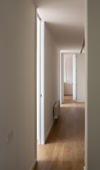 Perspective view of a long corridor with lateral light inlets. Modern architecture
