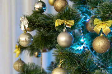 close-up Christmas tree with dove lights, golden decorations, balls and bows