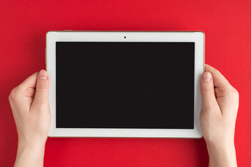 Technology development. Top above overhead view photo of female hands holding tablet isolated on red background with copyspace