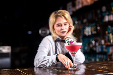 Girl barman formulates a cocktail in the beerhall
