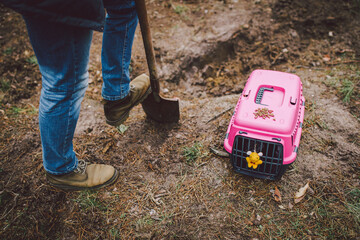 Scary horror scene man digs grave for animal in forest. Terrible loss of little friend. Death of pet. Funeral of cat. Gravedigger at work. RIP pets. Owner digging grave with shovel in forest for dog