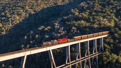 Maria Fumaça train passing on the Rio Pelotas railway bridge. Aerial view of the train passing on...