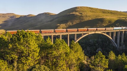Maria Fumaça train passing on the Rio Pelotinhas railway bridge. Aerial view of the train passing...