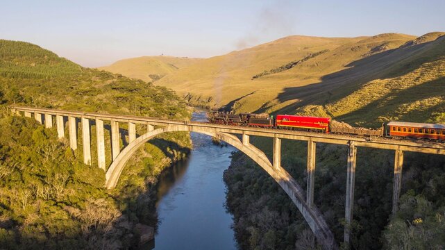 Maria Fumaça train passing on the Rio Pelotinhas railway bridge. Aerial view of the train passing on the bridge