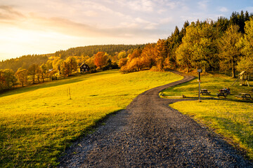 Naklejka premium Autumn landscape and country road at sunset time