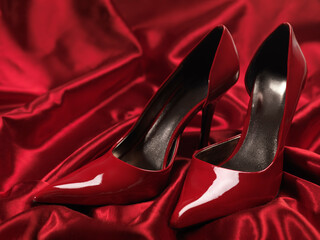 Red sexy high heel shoes on silky satin fabric