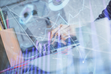 Double exposure of woman hands typing on computer and forex chart hologram drawing. Stock market...