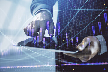 Fototapeta premium Double exposure of man's hands holding and using a digital device and forex graph drawing. Financial market concept.