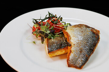 close up of a pan seared grill seabass fish fillet with tomato