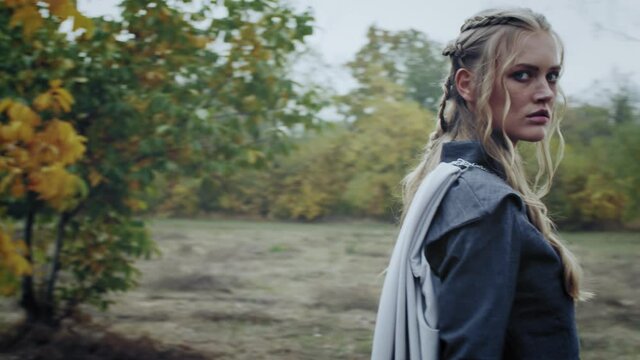 Beautiful young woman from medieval ages is walking in the woods, 4k