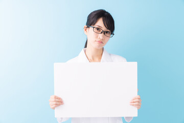 Naklejka premium 白衣の女性 ホワイトボード 考える