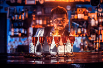 Portrait of bartending creates a cocktail behind the bar