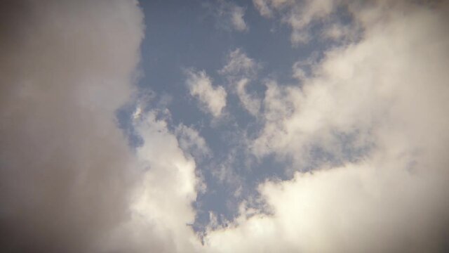 An edited timelapse of cumulus clouds engulfing the sky with an added film grain, vignette, and slight chromatic aberration for a grainy film look.