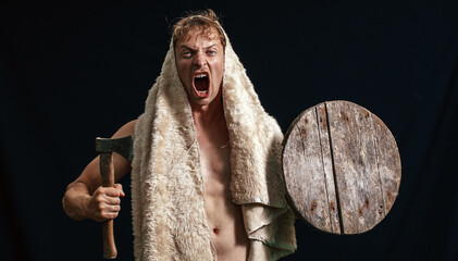 Portrait of a strong man. Strong male. Dark background. Ax.
