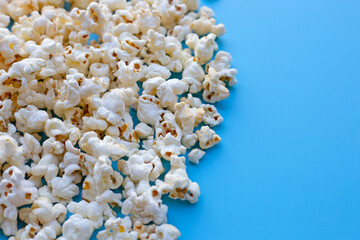 Popcorn on blue background. Copy space