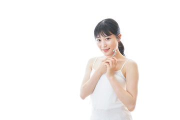かっさで肌をマッサージをする若い女性