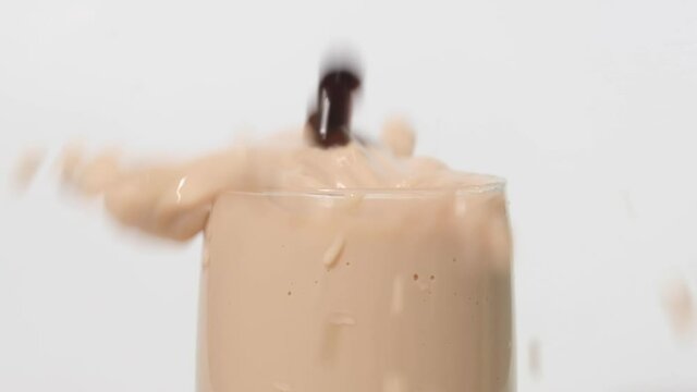 A slow motion footage of tapioca ball or pearl drop in milk tea. Pearl milk tea is famous drink in all country.