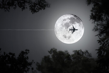 Fototapeta na wymiar Midnight shiny full moon background for travel and transportation logistic at night flight with silhouette blurry leaves and image of aircraft.
