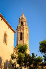 Fototapeta na wymiar San Pere Church's tower in Torredembarra, Tarragona, Spain - at sunset. Day with blue sky.