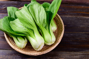 Fresh Bok Choy or Pak Choi(Chinese cabbage) in bamboo basket on wooden background, Organic...